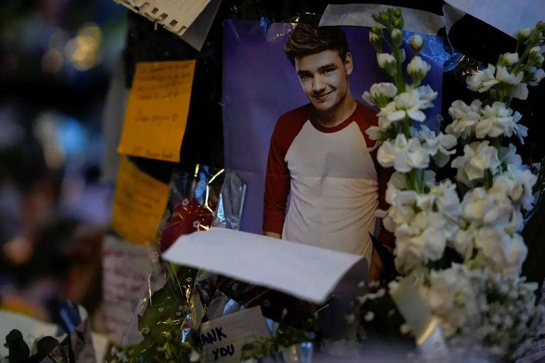 A picture of former One Direction singer Liam Payne adorns a memorial outside the hotel where he was found dead | Photo: AP