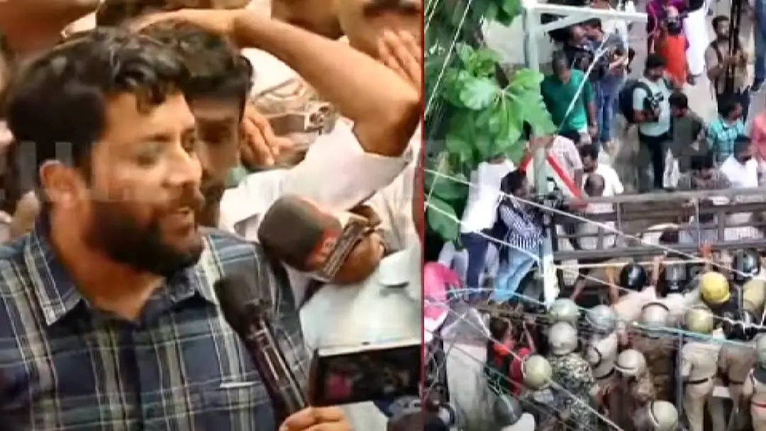 Shafi Parambil MP addresses the congress workers during the protest meeting . Police are seen trying to stop the marching UDF workers .