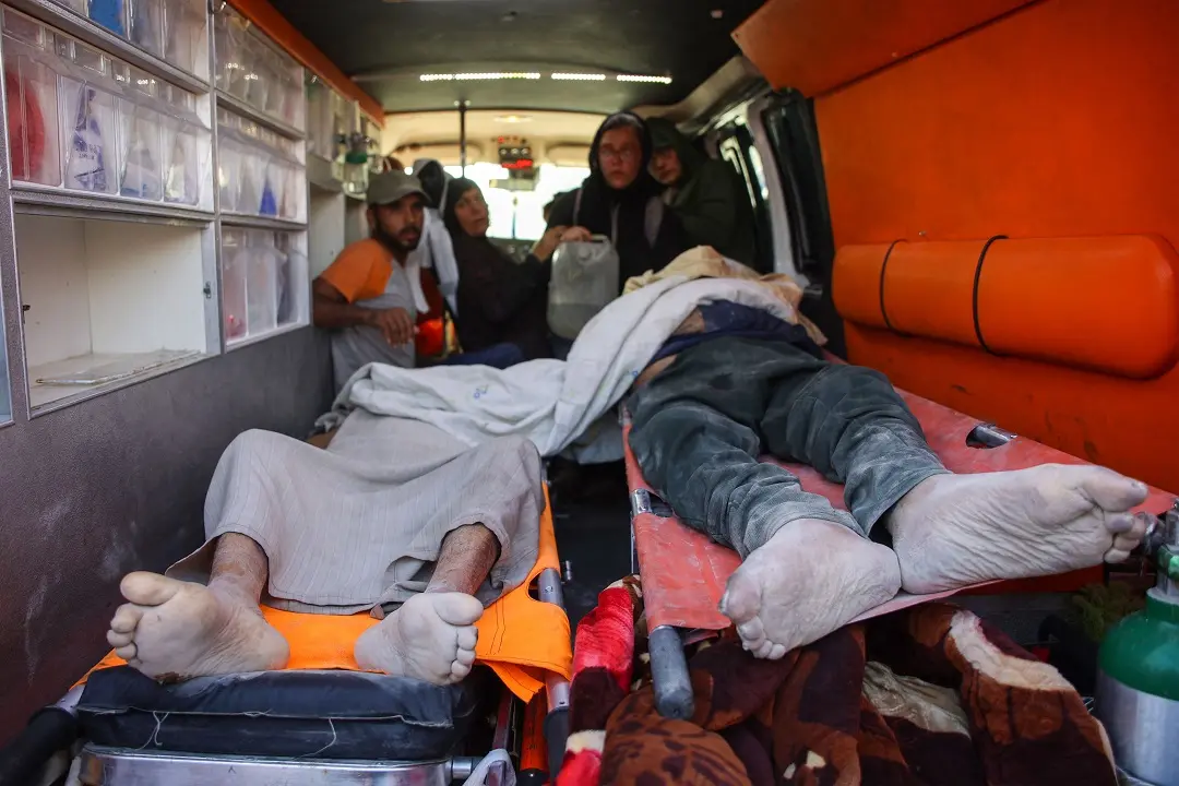 Relatives sit behind the bodies of two people killed during Israeli bombardment in Beit Lahia in the northern Gaza Strip| Photo: AFP