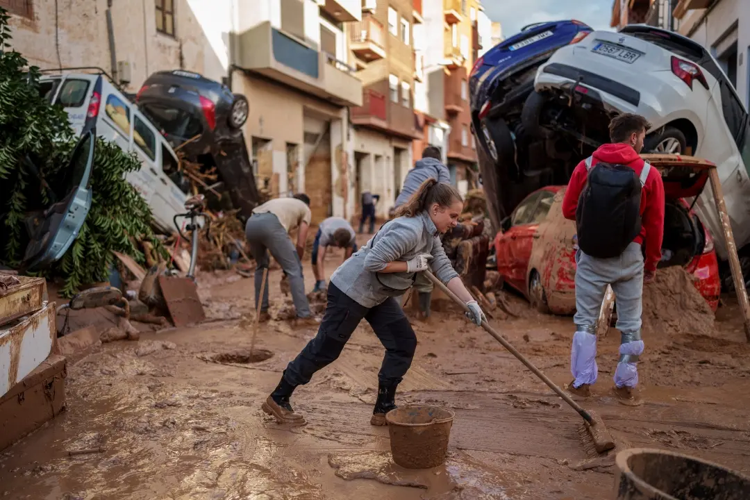 People cleaning the streets in an area affected by floods in Paiporta, a town in the region of Valencia, Spain on Saturday