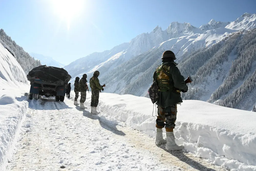Indian army soldiers walk along a road near Zojila mountain pass that connects Srinagar to the union territory of Ladakh | AFP