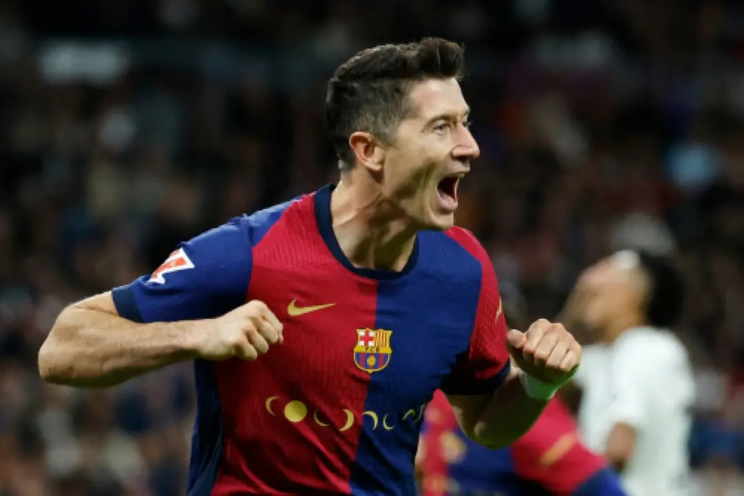 Barcelona's Polish forward #09 Robert Lewandowski celebrates scoring his team's second goal during the Spanish league football match between Real Madrid CF and FC Barcelona at the Santiago Bernabeu stadium in Madrid. | Photo: AFP