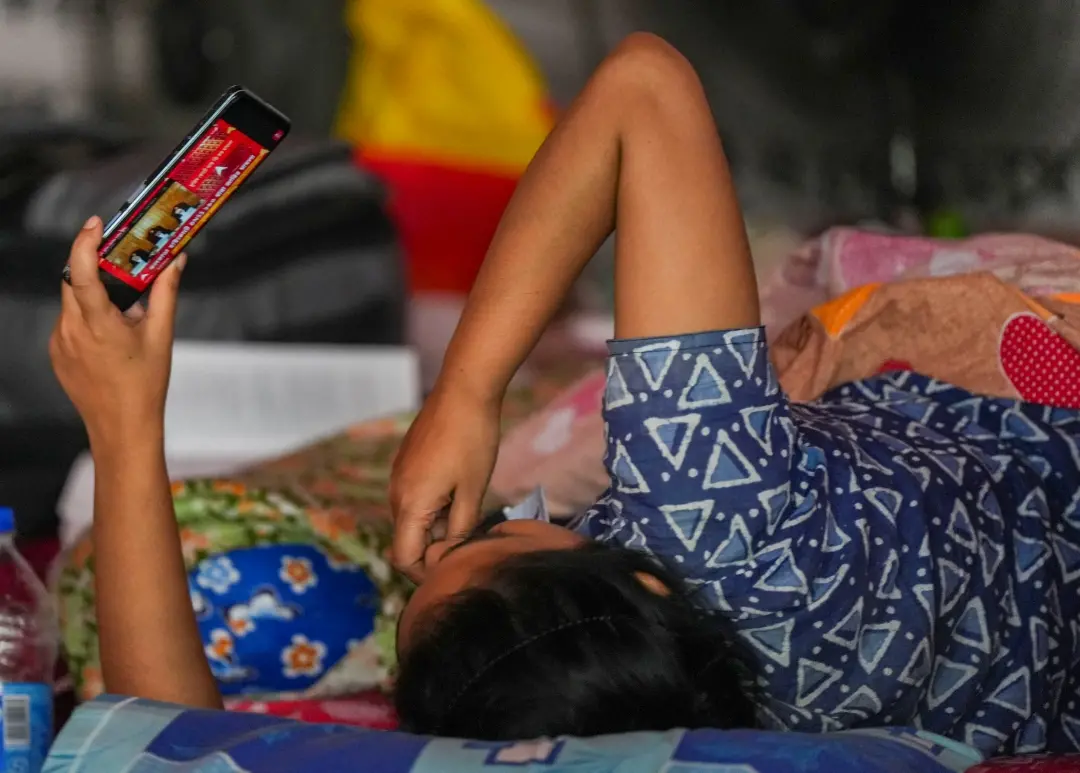 A Junior doctor who is on fast unto death lying on the bed watches the Supreme Court hearing on RG Kar rape and murder case in her own mobile, in Kolkata | Photo: PTI