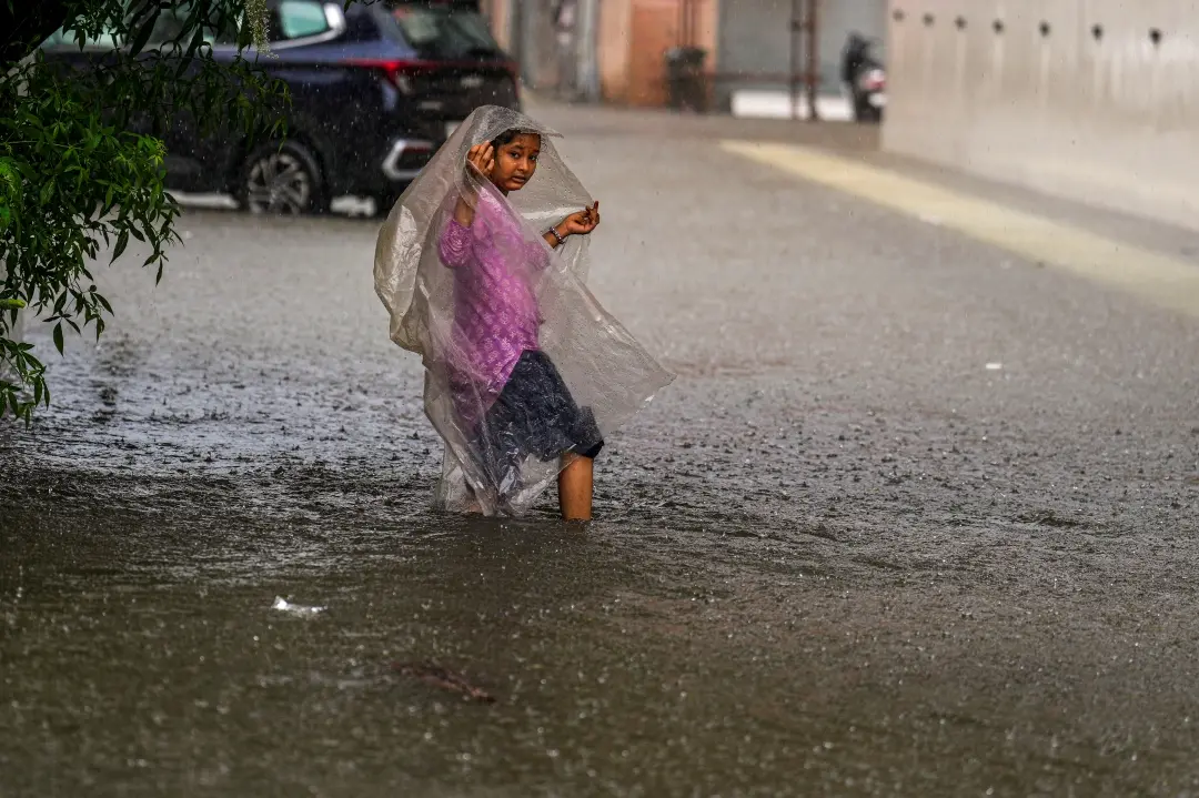 A young woman on a waterlogged road as the IMD has issued an red alert, predicting heavy rains in Chennai | Photo: PTI