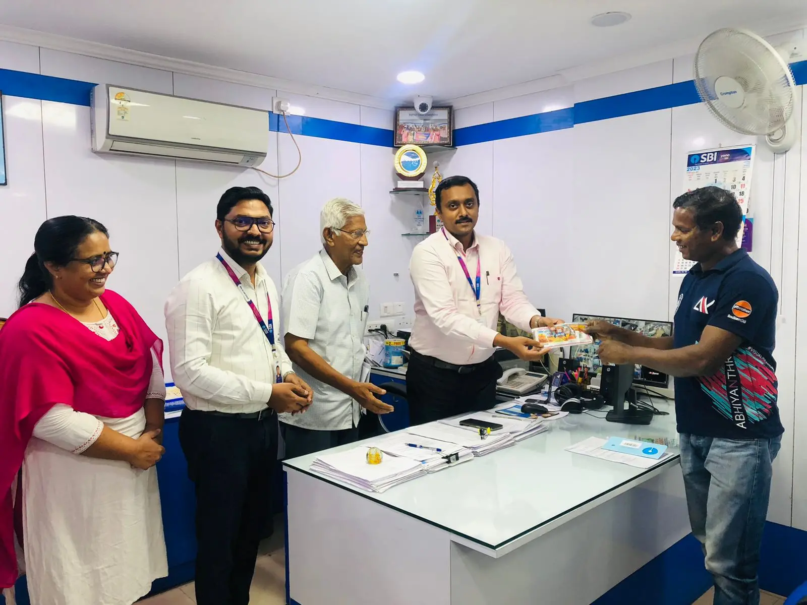 Summer Bumper winner handing over ticket to SBI branch manager in Aluva