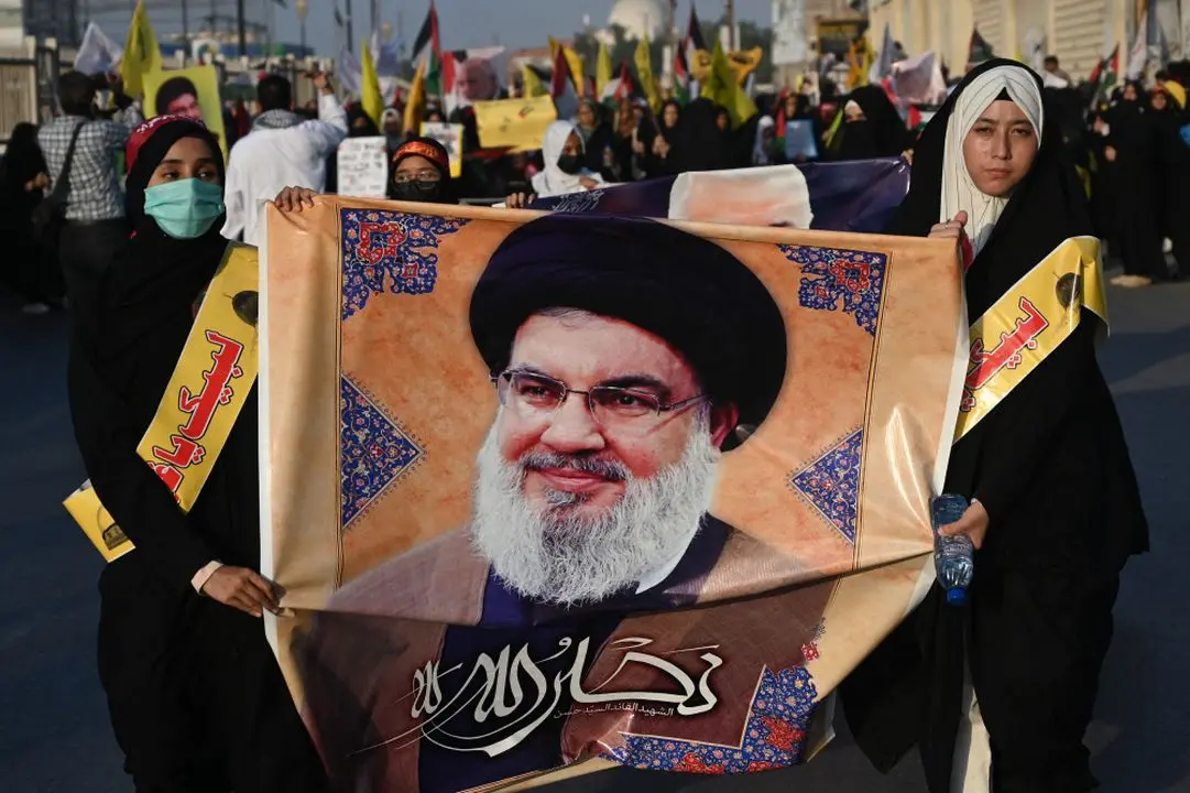 Shiite Muslim women holding a poster of Hassan Nasrallah, late leader of the Lebanese group Hezbollah.