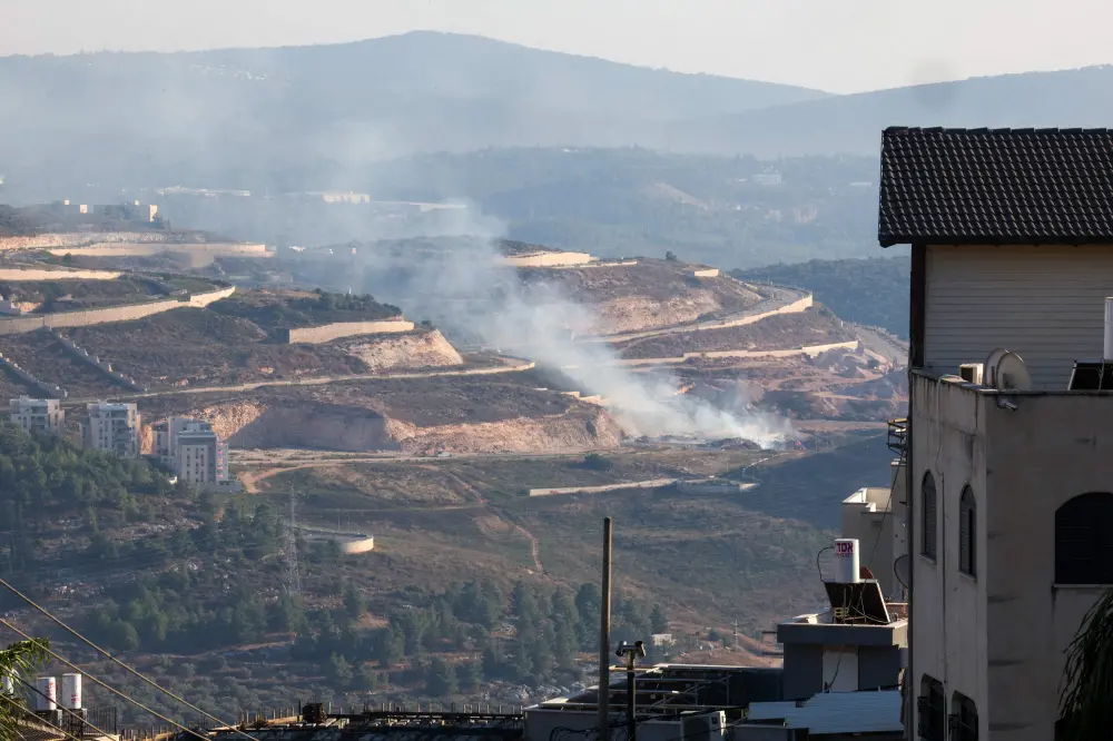 A picture taken from the norther Arab-Israeli village of Deir al-Asad shows smoke billowing near the northern Israeli town of Karmiel | AFP