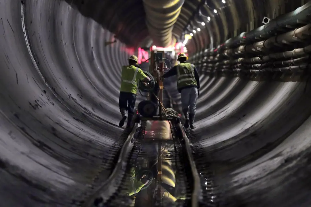 File photo shows tunnel workers pushing equipment up a rail track to a machine boring a 2.5-mile bypass tunnel for the Delaware Aqueduct in Marlboro, New York. Julie Jacobson/AP Photo