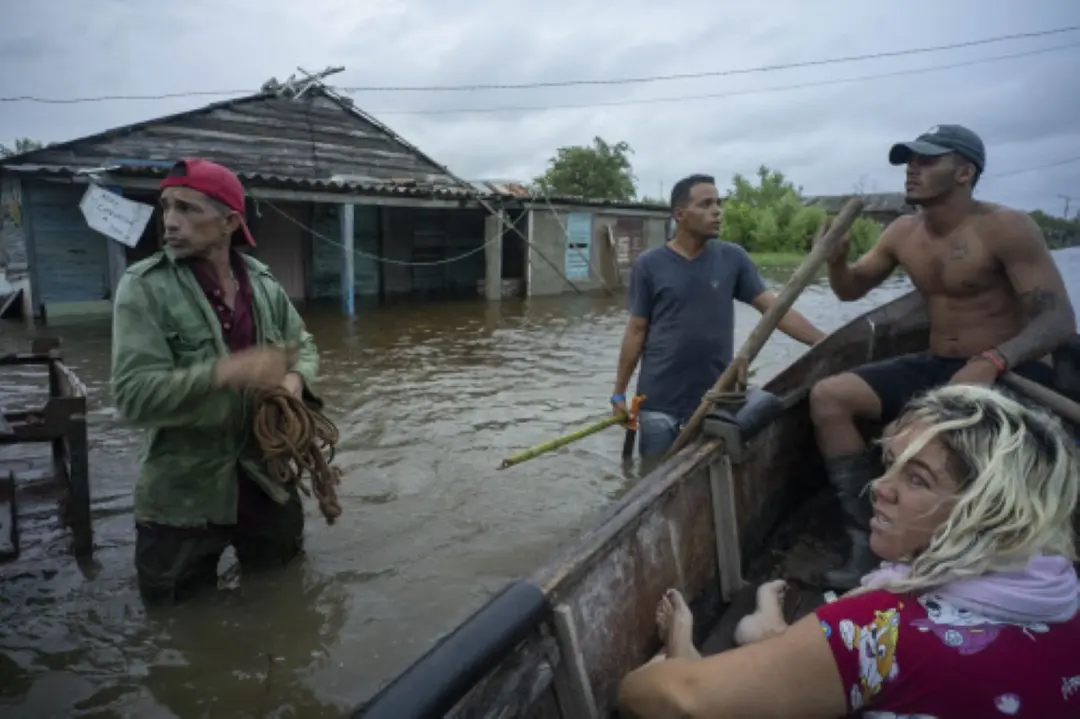 Neighbors chat on a flooded street after the passage of Hurricane Helene in Guanimar, Artemisa province, Cuba on Wednesday. | Photo: AP