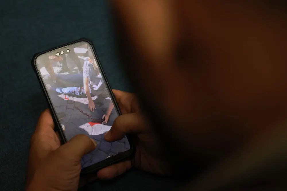 A man watches a video, published on social media, showing a wounded man | AFP