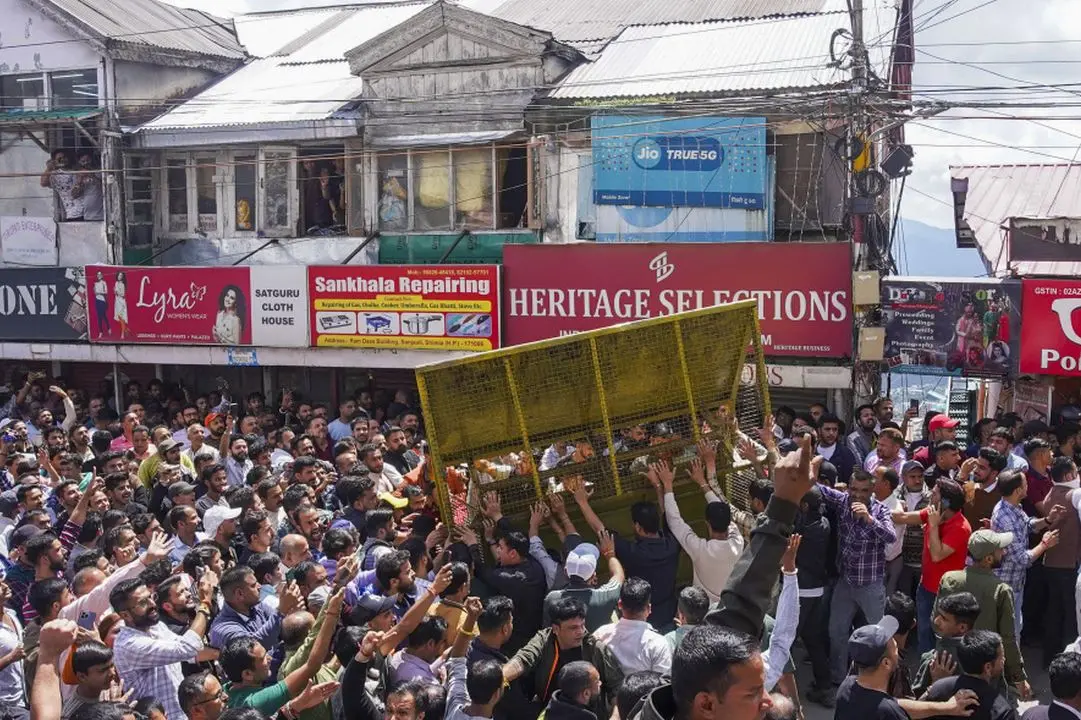 Protestors, who had gathered on the call of Hindu groups, remove a security barricade during a protest demanding the demolition of an illegal structure in a mosque, at Sanjauli locality in Shimla.