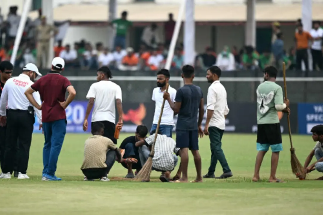 Groundsmen work on the field before the start of the first day play of the one-off Test cricket match between Afghanistan and New Zealand at the Shaheed Vijay Singh Pathik Sports Complex in Greater Noida. | Photo: AFP
