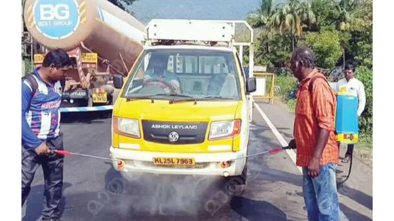 Tamil Nadu health department workers spray disinfectant over vehicles that are coming from Kerala