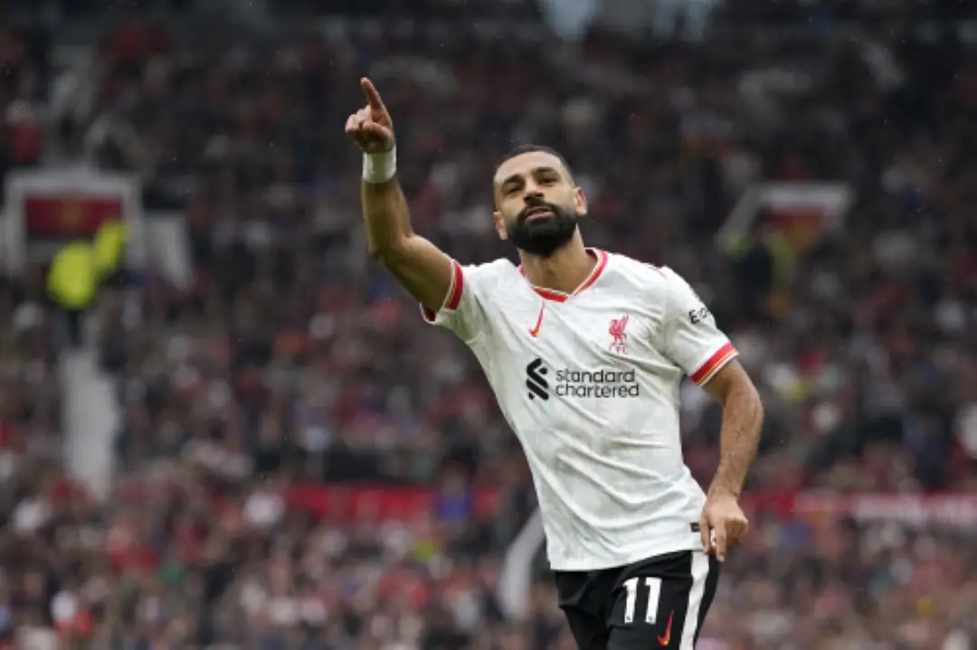Liverpool's Mohamed Salah celebrates after scoring his side's third goal during the English Premier League soccer match between Manchester United and Liverpool at Old Trafford. | Photo: AP