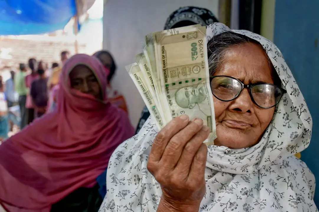 File photo of a beneficiary showing currency notes after drawing them from her old age pension account