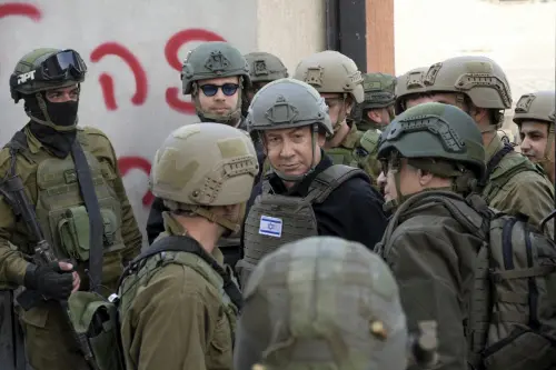 Israeli Prime Minister Benjamin Netanyahu, center, wears a protective vest and helmet as he receives a security briefing with commanders and soldiers in the northern Gaza Strip, on Monday, Dec. 25, 2023. (AP/PTI Photo)