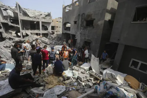 Palestinians look at the destruction after an Israeli strike on a residential building in Nuseirat Refugee Camp, Gaza Strip, on Sunday. l Photo: AP