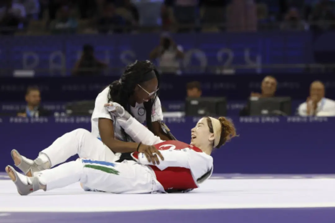 Zakia Khudadadi from the Paralympic Refugee Team, bottom, celebrates her bronze medal in Para Taekwondo during the Paralympic Games in Paris on Thursday. | Photo: AP