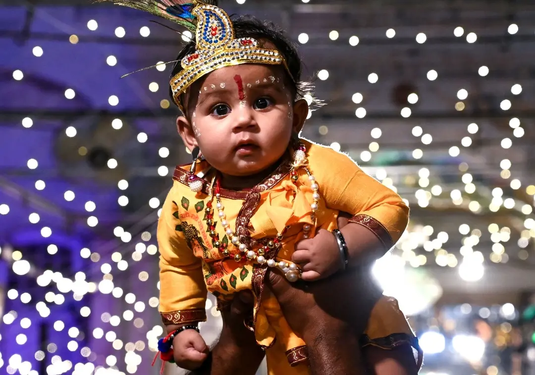 A baby dressed as lord Krishna visits a temple on the eve of Janmashtami festival at Durgiana temple in Amritsar | Photo: AFP