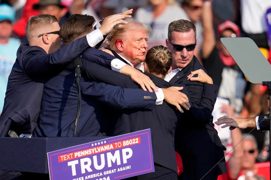 Republican presidential candidate former President Donald Trump is helped off the stage after the shooting incident | File Photo: AP