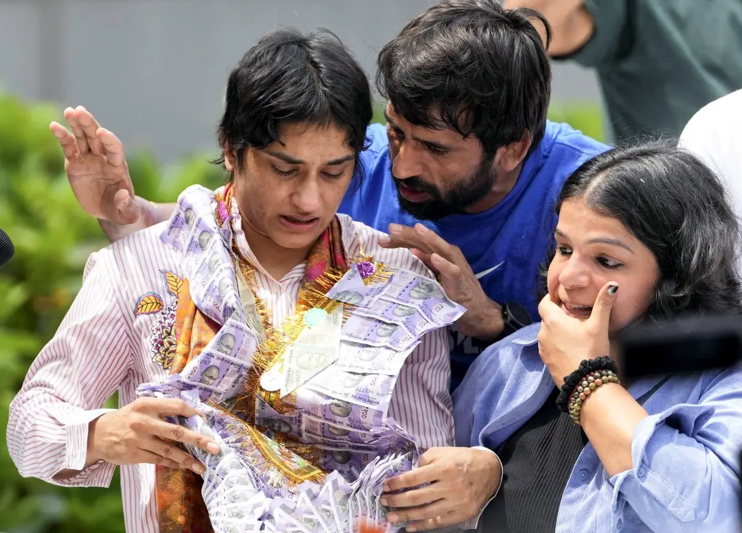 Wrestler Vinesh Phogat gets emotional on her arrival after Paris Olympics heartbreak, at IGI airport, in New Delhi, Saturday. Wrestlers Bajrang Punia and Sakshi Malik are also seen. | Photo: PTI