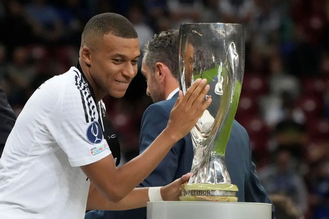 Real Madrid's Kylian Mbappe touches the trophy during the medal ceremony for the UEFA Super Cup Final soccer match between Real Madrid and Atalanta at the Narodowy stadium in Warsaw. | Photo: AP