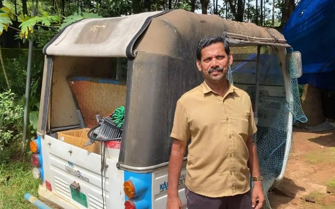 Driver Nanban Shamsuddin with his broken electric auto rickshaw