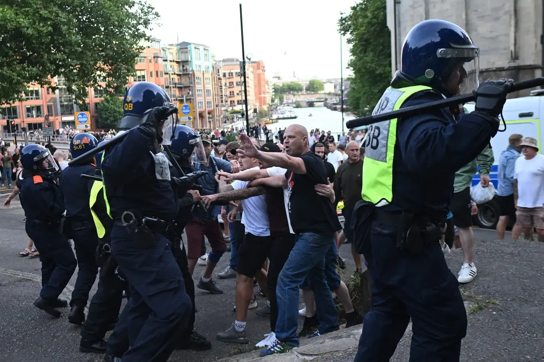 Police officers face off with protesters during the 'Enough is Enough' demonstration called by far-right activists in Bristol | Photo: AFP