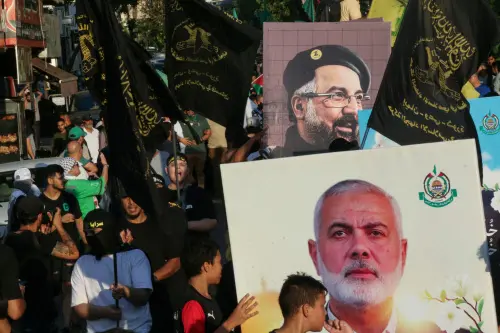 People take part in a march called by Palestinian and Lebanese youth organisations in the southern Lebanese city of Saida, on August 5, 2024, to protest against the assassination of Hamas chief Ismail Haniyeh (portrait bottom) and Hezbollah military commander Fuad Shukur (portrait top). | Photo: AFP