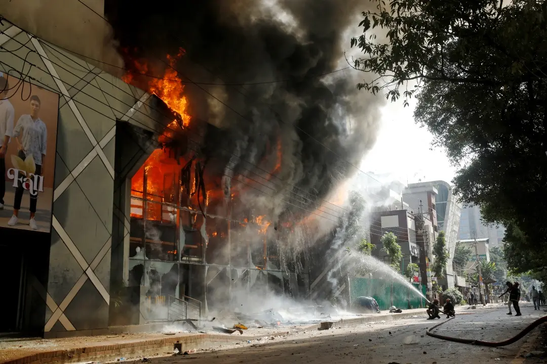 Firefighters douse a fire engulfing a shopping center, set on fire by protesters during a rally against Prime Minister Sheikh Hasina and her government demanding justice for victims killed in recent countrywide deadly clashes, in Dhaka, Bangladesh | Photo: AP