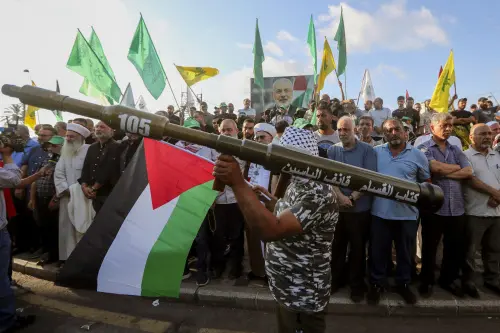 A supporter of the Lebanese Islamic group and the Islamist Hamas movement holds a mock rocket