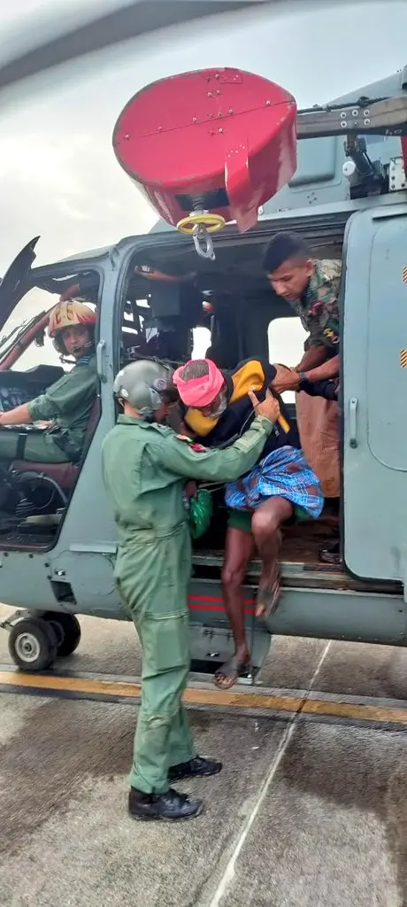 IAF personnel rescue stranded people and carry them to safer places on helicopters during a search and rescue operation