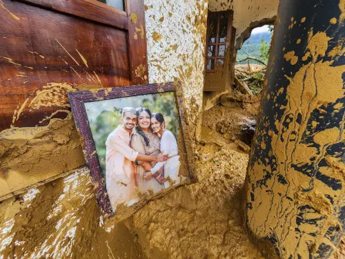 A framed photograph lies partially covered in mud at a damaged house after landslides hit hilly villages in Kerala's Wayanad district on Tuesday. There was no immediate information available on the people in the picture. | Photo: AP