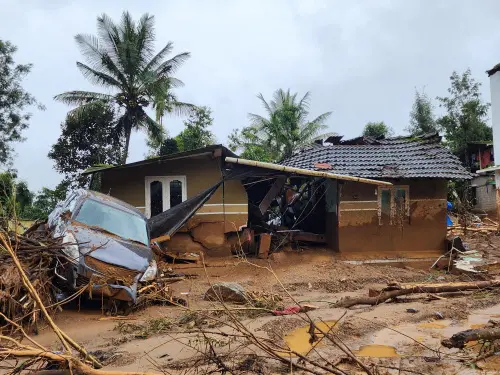 A damaged car and a house after landslides hit hilly villages in Wayanad. | Photo: AP