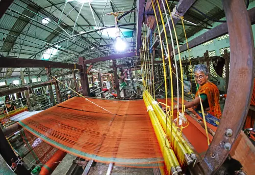 Artisans weave sarees on a handloom at a workshop