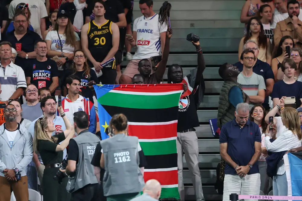 Fans of South Sudan hold their country's national flag and shout slogans during the national anthems | AFP