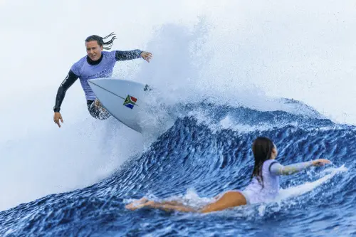 Sarah Baum, of South Africa, left, surfs as another surfer paddles past on a training day before the 2024 Summer Olympics, in Teahupo'o, Tahiti. | Photo: AP