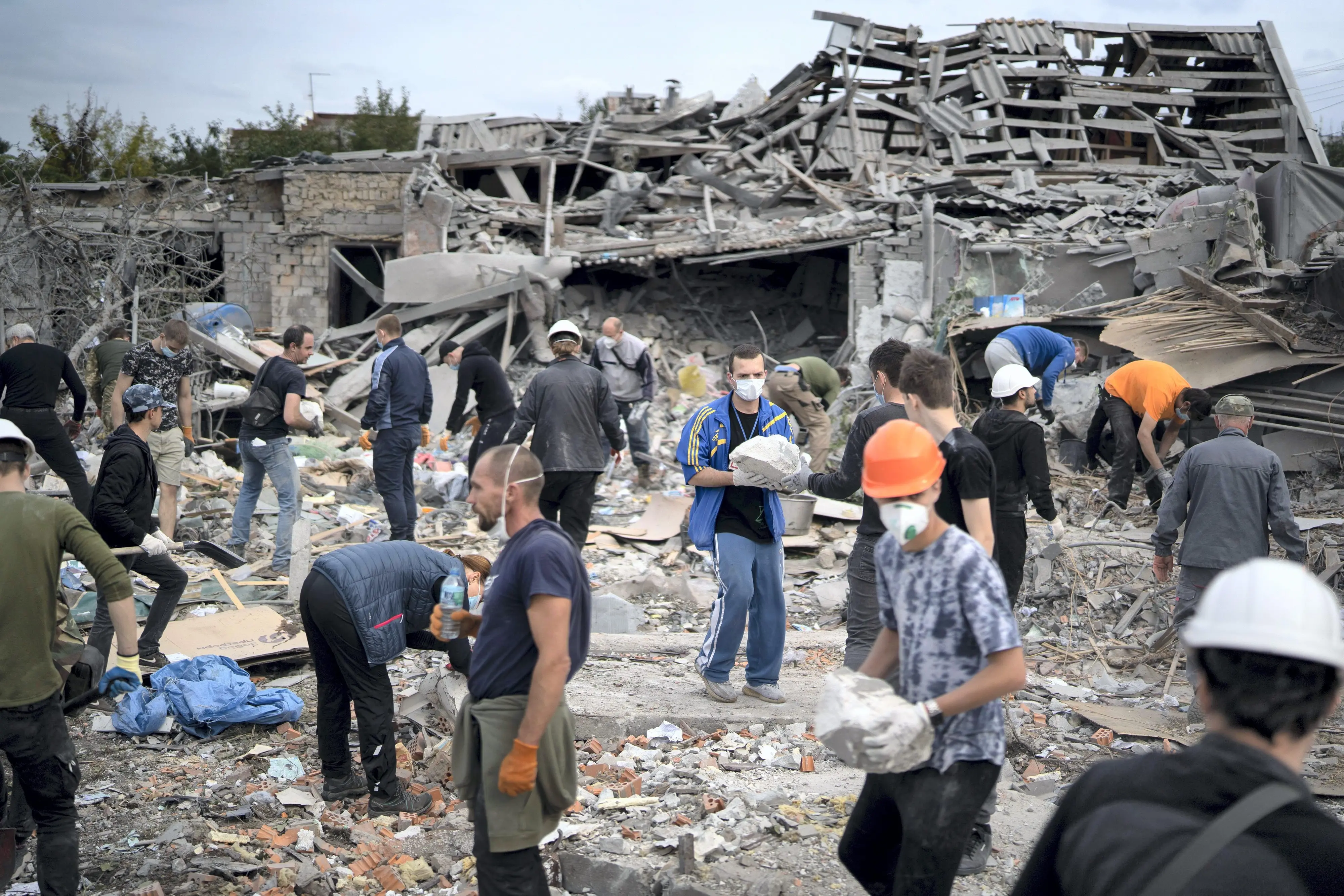 Volunteers work to clean the debris on a site where several houses were destroyed after a Russian attack at a residential area in Zaporizhzhia. Photo: AP