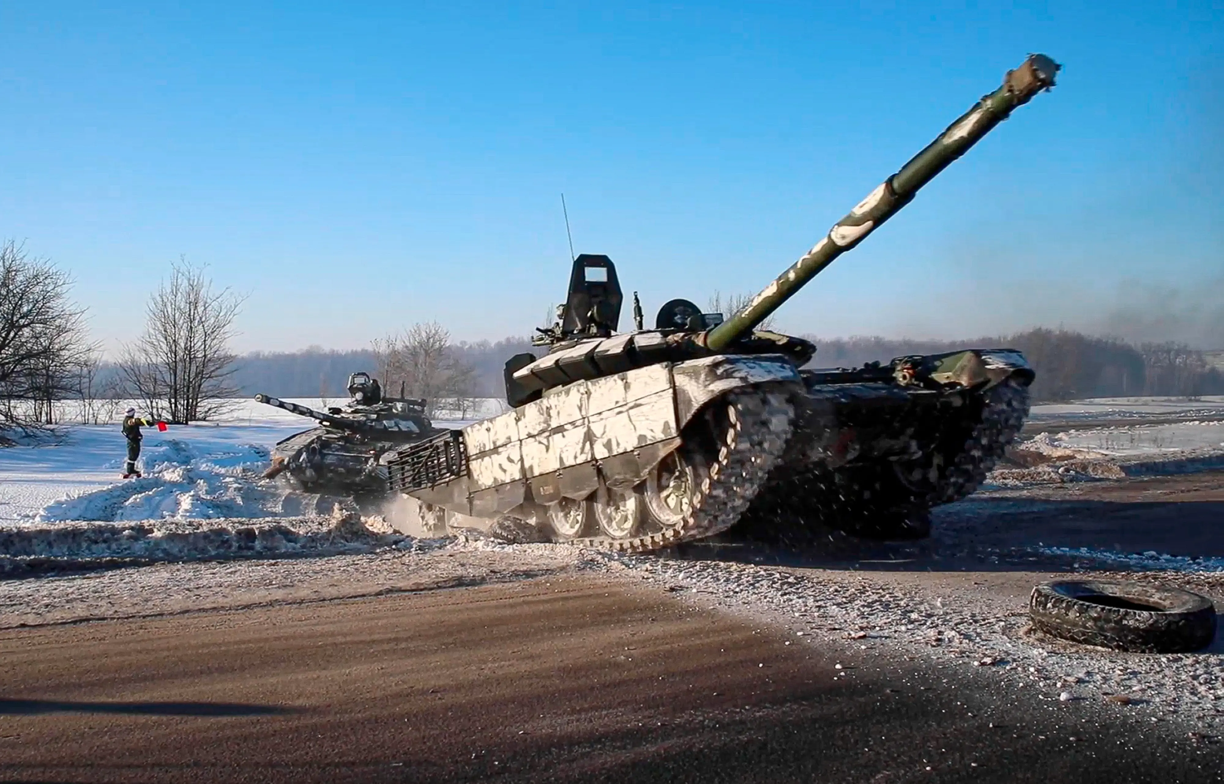 In this photo taken from video provided by the Russian Defense Ministry Press Service on Tuesday, Feb. 15, 2022, Russian army tanks move back to their permanent base after drills in Russia