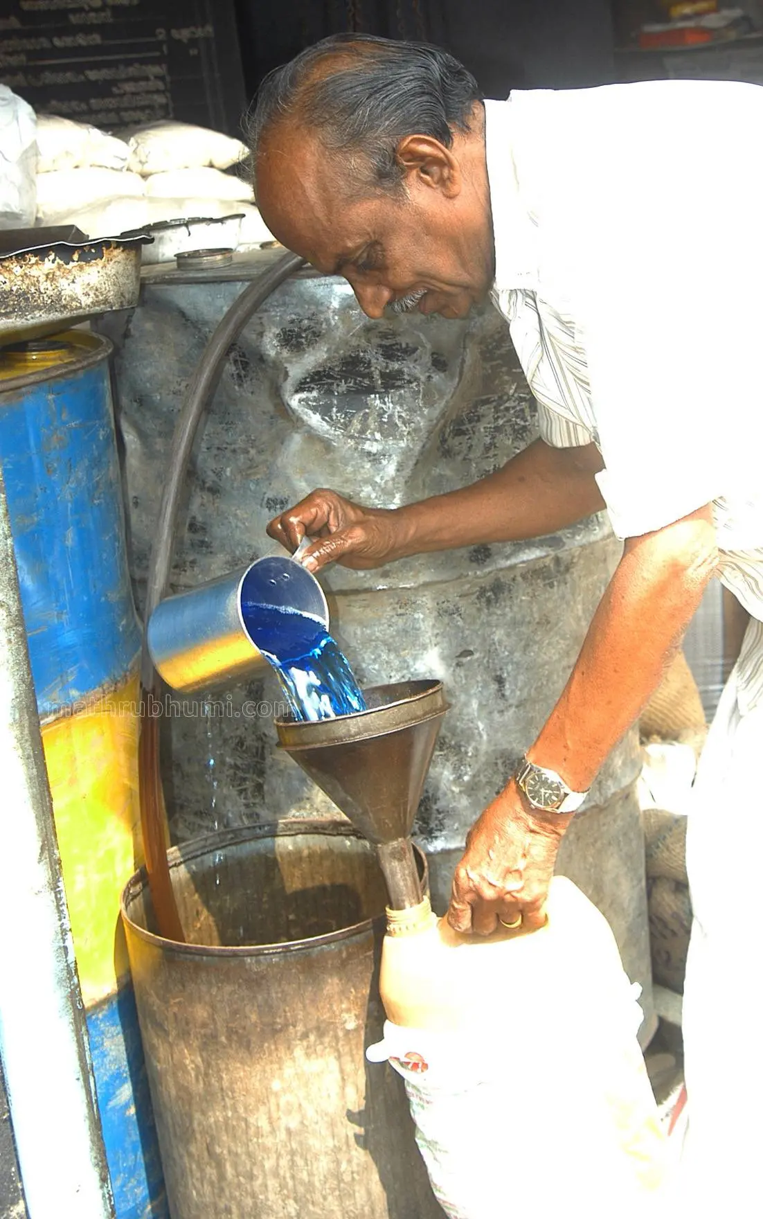 A ration shop keeper supplies kerose to a consumer. Photo: Mathrubhumi Archives