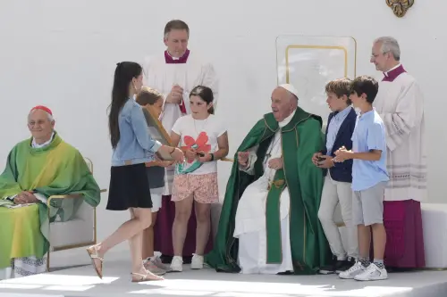 Children bring gifts to Pope Francis at the end of a mass he presided over in Trieste's monumental square Piazza dell'Unita' d'Italia, in northern Italy on Sunday | Photo: AP/PTI
