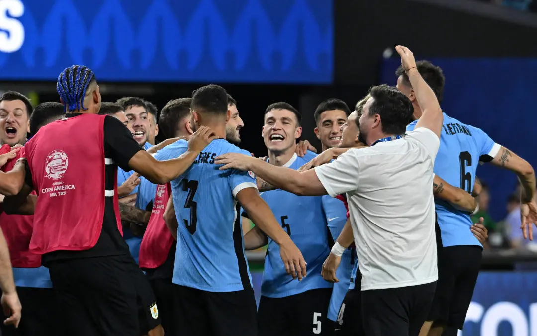 Uruguay's midfielder Manuel Ugarte (C) celebrates with teammates after scoring in a penalty shoot-out to win the Conmebol 2024 Copa America tournament quarter-final football match between Uruguay and Brazil