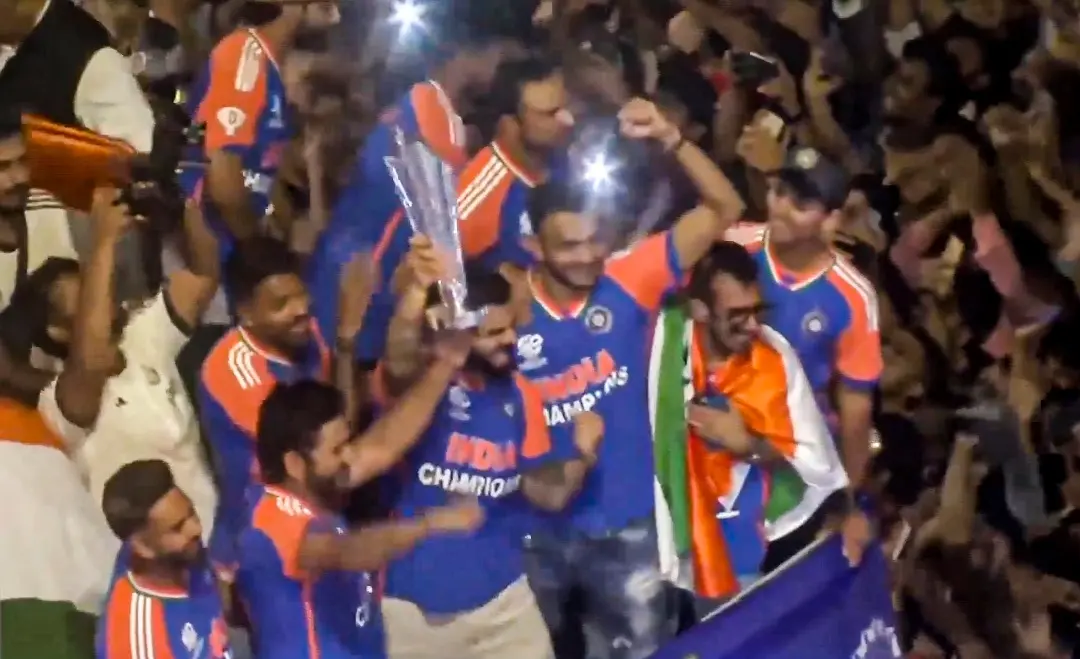 Players of the T20 World Cup-winning Indian cricket team with the championship trophy acknowledge fans during their open bus victory parade | Photo: PTI