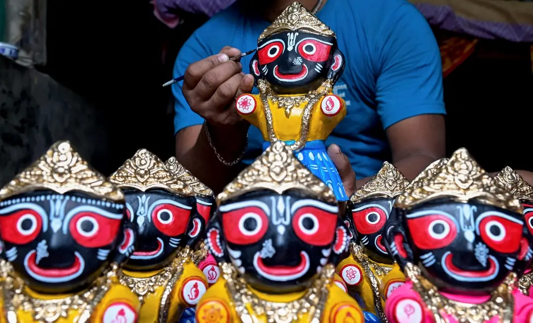 An artist gives finishing touches to an idol of Lord Jagannath ahead of the Rath Yatra festival