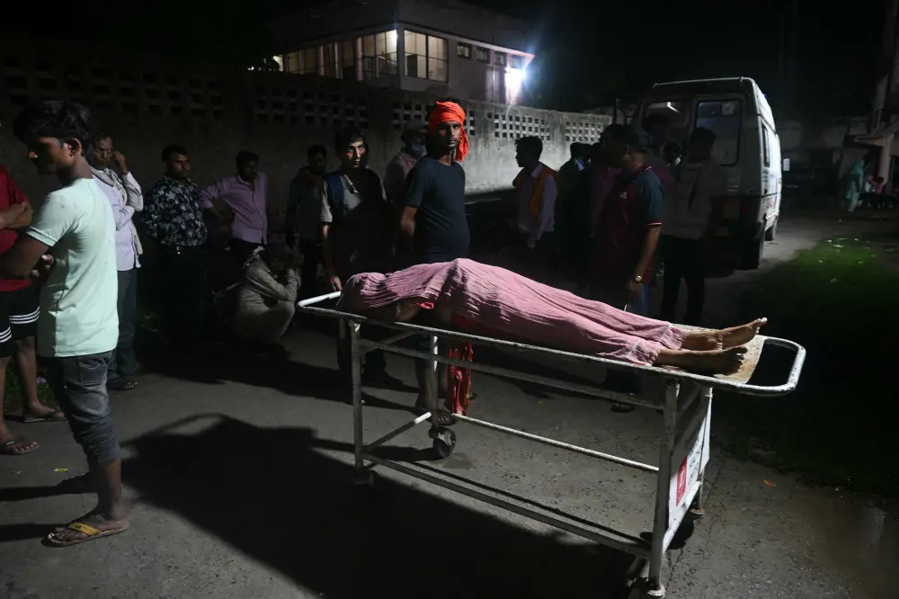 Relatives gather around the body of a victim | AFP
