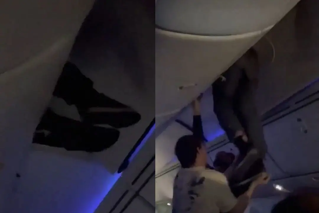 Passengers helping a man get off the overhead luggage cabin after the turbulence hit an Air Europe flight