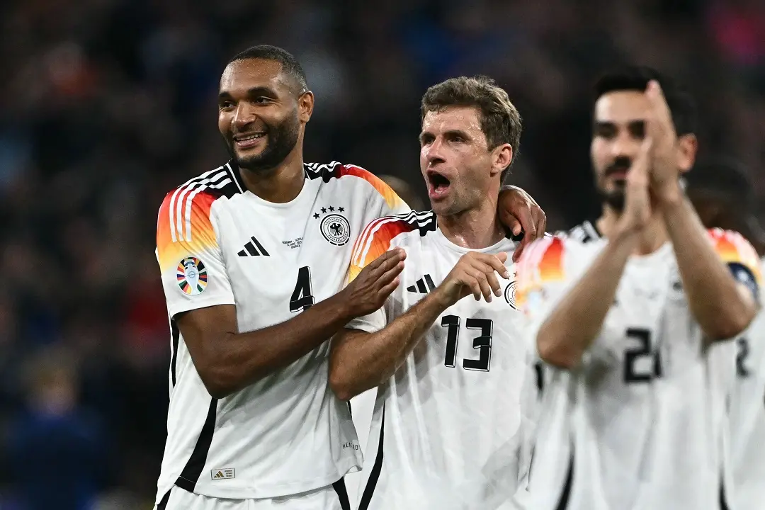 Germany's defender #04 Jonathan Tah (L) and Germany's forward #13 Thomas Mueller celebrate after winning the UEFA Euro 2024 Group A football match between Germany and Scotland at the Munich Football Arena in Munich | Photo: AFP