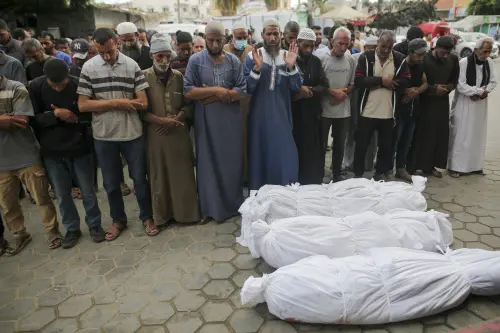 Palestinians pray next to the body of relatives killed in an Israeli airstrike, outside the morgue in Al-Aqsa Martyrs Hospital in Deir al Balah, the Gaza Strip l Photo: AP