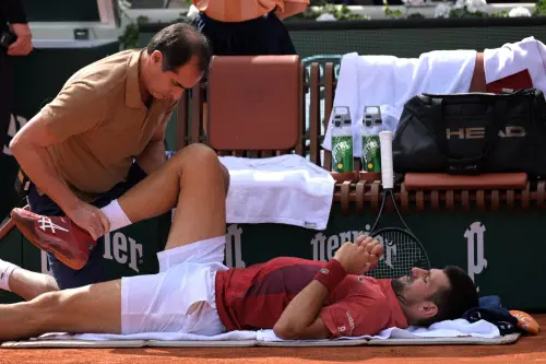 Serbia's Novak Djokovic receives medical treatment during his men's singles round of sixteen match against Argentina's Francisco Cerundolo on Court Philippe-Chatrier on day nine of the French Open tennis tournament at the Roland Garros Complex in Paris. l Photo: AFP