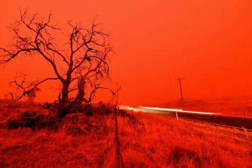 A long exposure picture shows a car commuting on a road as the sky turns red from smoke of the Snowy Valley bushfire on the outskirts of Cooma on January 4, 2020.  (file photo: AFP)